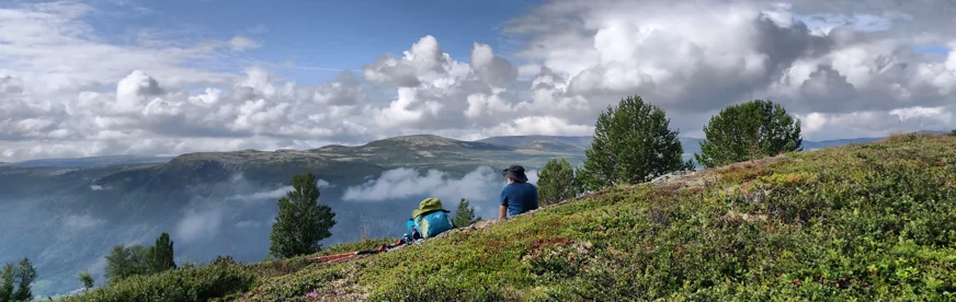 Pilger rasten auf einer Anhöhe mit Blick über das norwegische Fjell am Olavsweg