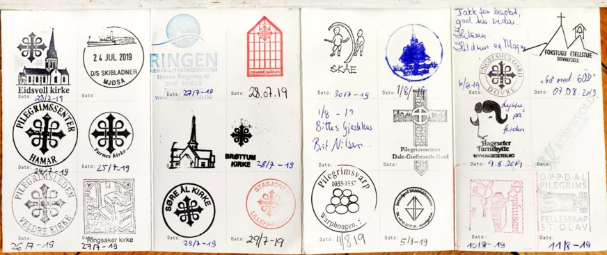 Aufgeschlagener Pilgerpass mit gesammelten Stempeln von Kirchen und Unterkünften am Olavsweg